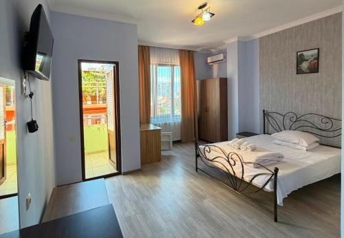 a bedroom with a bed with white sheets at Marani Hotel in Batumi