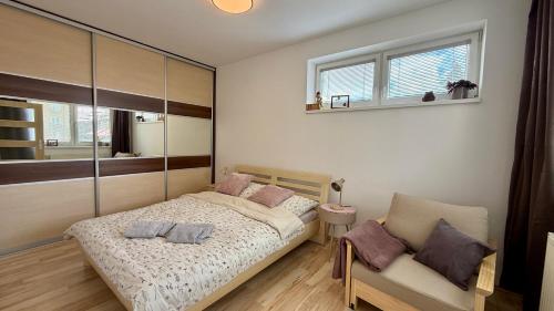 a bedroom with a bed and a chair and a window at Šturka Apartment in Martin