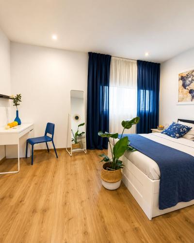 a bedroom with a bed and a table and a desk at Orange Vibes Guest house in Paterna