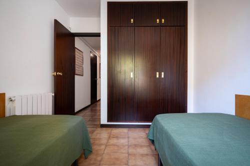 a room with two beds and a wooden door at AT121 Con piscina y cerca de la playa in Torredembarra