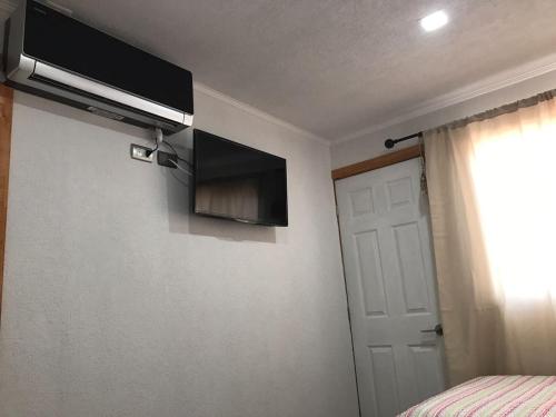 a bedroom with a bed and a television on the wall at Residencial Victoria Said in Linares