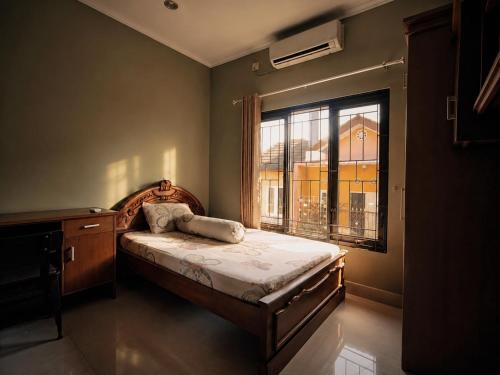 a small bedroom with a bed and a window at Audi's Homestay near Kotagede in Gondowulung