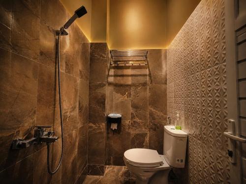 a bathroom with a shower and a toilet in it at Audi's Homestay near Kotagede in Gondowulung
