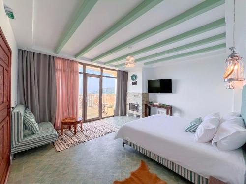 a hotel room with a bed and a balcony at Oussoul House in Feddane Saïdi