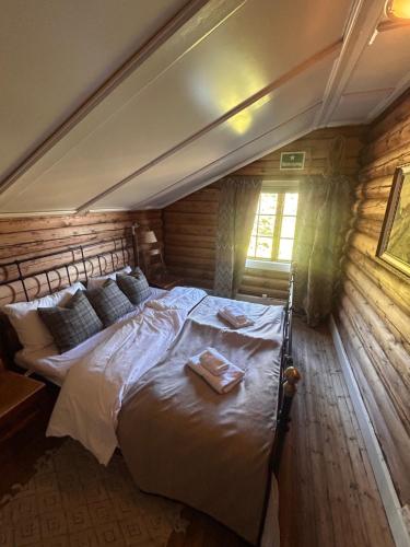a bedroom with a bed in a wooden room at Knutehytta in Kongsberg