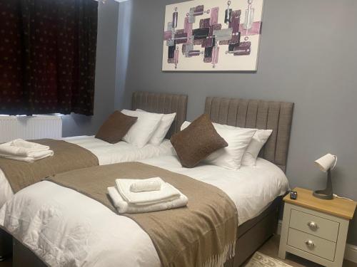 two beds sitting next to each other in a bedroom at Holiday home with 3 double bedrooms all En-suite in Craven Arms
