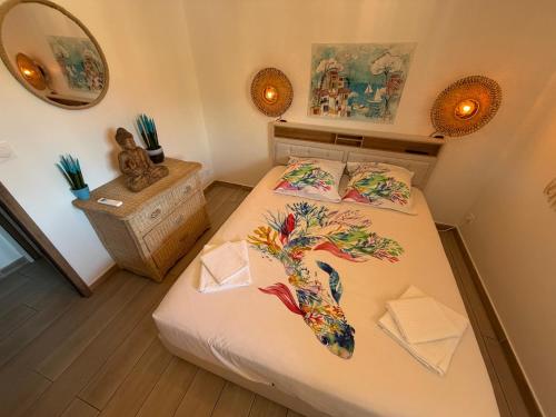 a bedroom with a bed with a fish on it at T2 "Bohême" vue mer, centre ville tout à pied in Le Lavandou