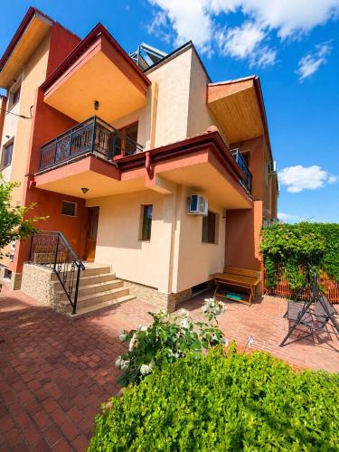 a house with a balcony and a brick patio at Vila Patricia in Eforie Sud