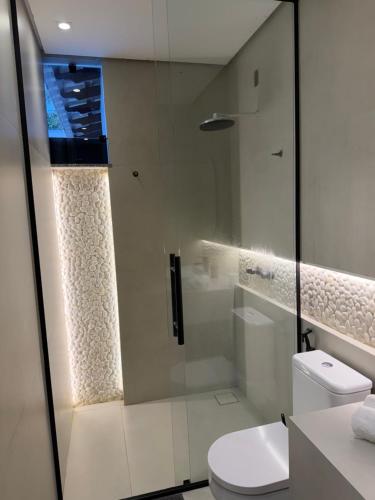 a bathroom with a toilet and a glass shower at Casa no Bairro Reserva Real in Montes Claros