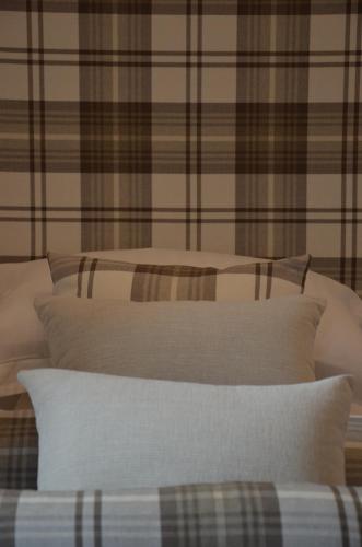 two beds with white pillows and a plaid wall at Edinburgh37 in Edinburgh