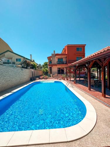 a swimming pool with blue water in front of a building at Vila Patricia in Eforie Sud
