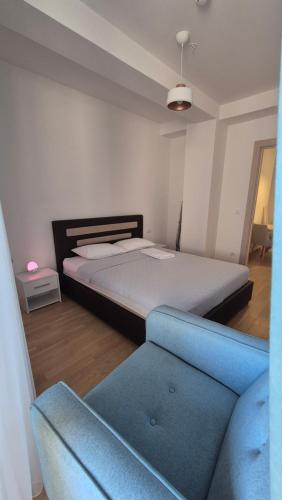 a bedroom with a bed and a blue couch at Rafailovici Beachfront Apartment 2 in Budva