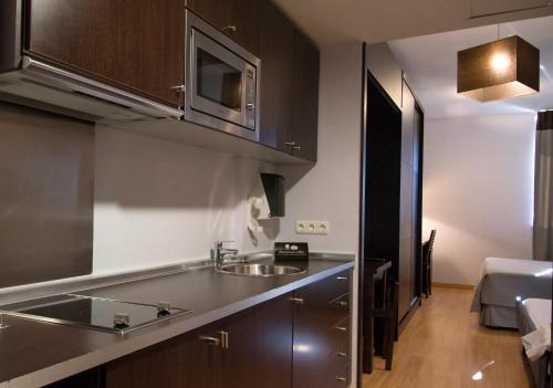 una cocina con fregadero y microondas en Zenit Hall 88 Studios, en Salamanca
