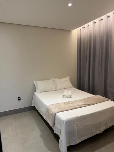 a bedroom with a bed with two slippers on it at Casa no Bairro Reserva Real in Montes Claros