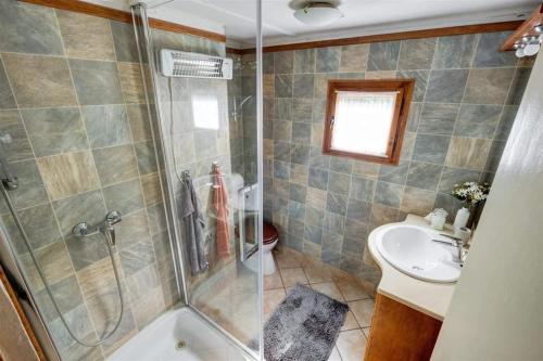 a bathroom with a shower and a toilet and a sink at Bakancsos Kulcsosház in Dobogókő