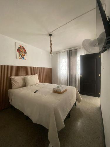 a bedroom with a white bed and a window at Los Aposentos Antigua in Antigua Guatemala