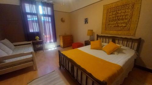 a bedroom with a bed with yellow pillows on it at Chez Valérie côté Sud in Saint-Jean-du-Gard