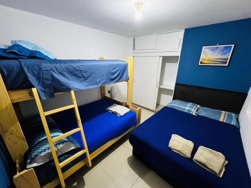 a bedroom with two bunk beds and a blue wall at Apto 3 dormitorios cerca al mar B in Pacasmayo