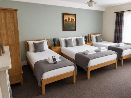 a hotel room with three beds in a room at The Cornerhouse in Frome