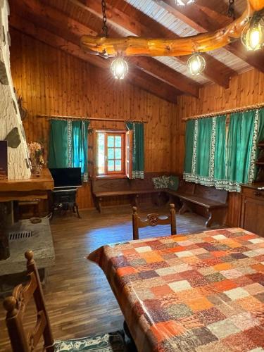 a room with a bed and a table and a piano at Baita immersa nel verde in Salabertano