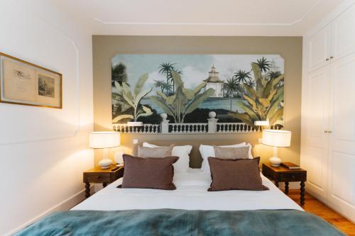 a bedroom with a large white bed with two lamps at Quinta da Boa Esperança in Torres Vedras