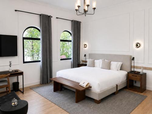 a bedroom with a large white bed and a desk at Casa Lerma in Mexico City