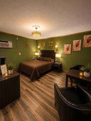a bedroom with a bed and green walls and a couch at Frontier Lodge in Lander