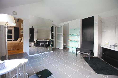 a room with a bathroom with a tub and a bedroom at Villa Tiffany in Braine-lʼAlleud