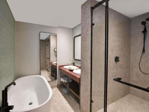 Mövenpick Kigali في كيغالي: حمام مزود بحوض استحمام ومغسلة ودش