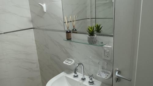 a white bathroom with a sink and a mirror at Apart Saavedra in Concordia
