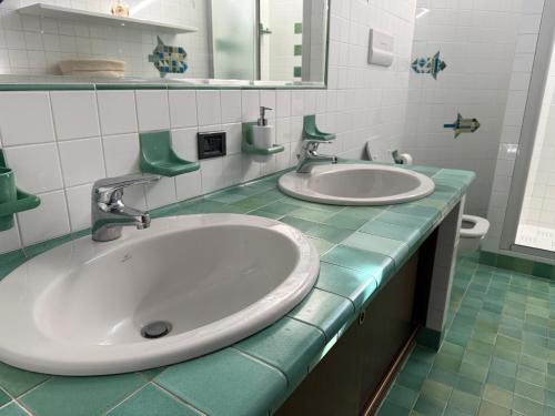 a bathroom with two sinks and a green counter top at Residence Ai Melograni in Silea