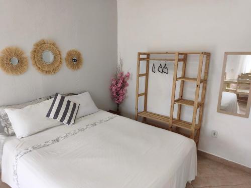 a bedroom with a white bed and mirrors on the wall at Solares Boa Estada in Búzios