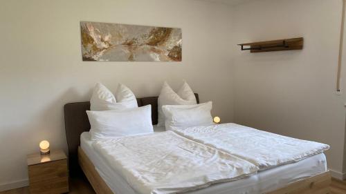 a bedroom with a bed with white sheets and pillows at Bergidylle- Saniert und Hochwertig mit Massivholzmöbeln, Sonnenterrasse in der Natur, fußgängig ins Zentrum in Kurort Altenberg