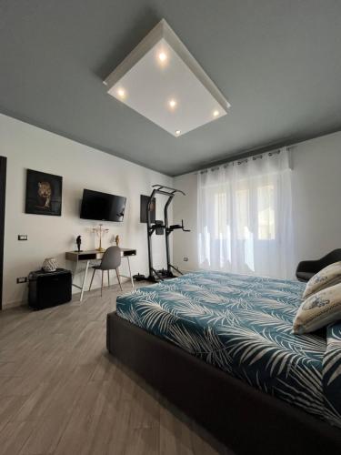 a bedroom with a bed and a desk and a television at La Base Fitness House in Decimomannu