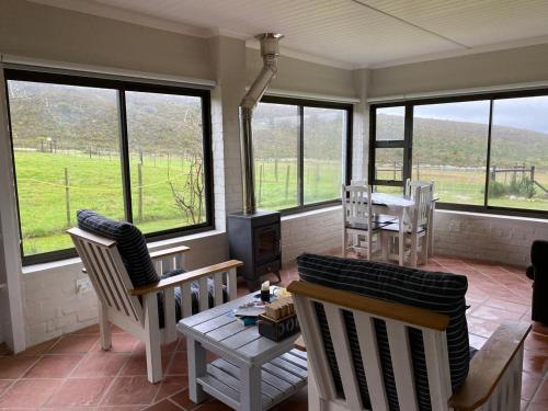 a living room with chairs and a table and windows at Die Tuin in Stanford