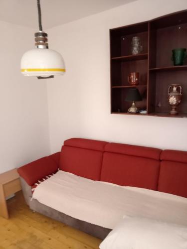a red couch in a living room with a lamp at Centar in Valjevo