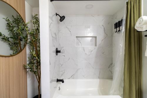 a bathroom with a white tub and a mirror at VIBES! Free Parking, Piano, King Bed in Washington, D.C.