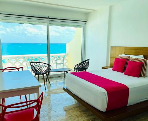 a bedroom with a bed and a view of the ocean at Ventanas al Paraiso Apartment Cancun in Cancún