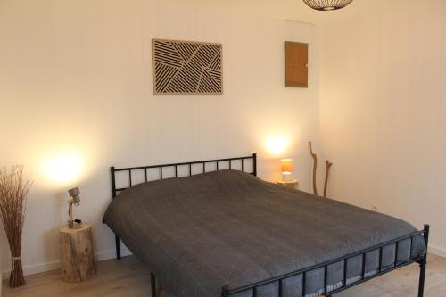 a bedroom with a bed and two lights on the wall at Le Cocon des Acacias in Tournon-sur-Rhône