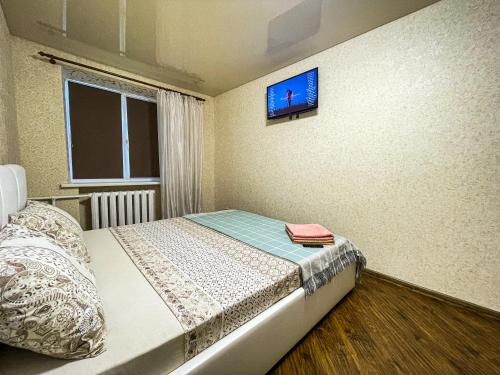 a bedroom with a bed with a tv on the wall at Апартаменти ТЦ Галактика in Kremenchuk