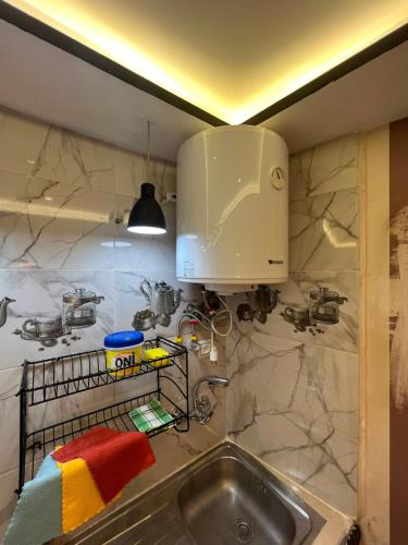 a kitchen with a sink and a microwave at Bab Rmouz apartment in Tétouan