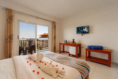 a bedroom with a bed with a view of a balcony at Malika Blue Hotel Nungwi, Zanzibar in Banda Kuu