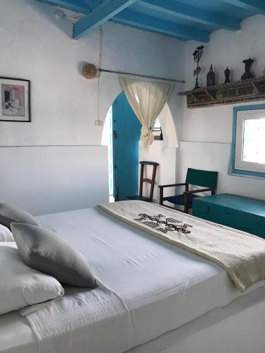 a large bed in a room with a blue ceiling at El Baraka in Houmt Souk