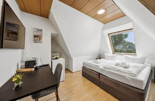 a bedroom with a bed and a desk at Hotel Knurrhahn DZ in Wilhelmshaven