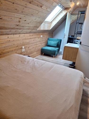 a bedroom with a bed and a green chair at Heuvelzicht in Wortegem