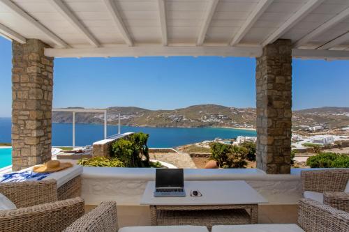a view from the balcony of a house with a laptop on a table at South Star private Villa in Mikonos