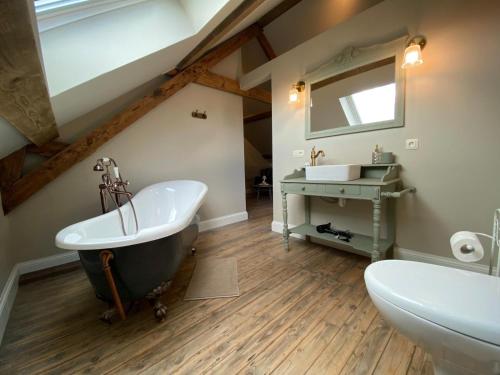 a bathroom with a bath tub and a sink at B&B Tierlantijn in Hamont