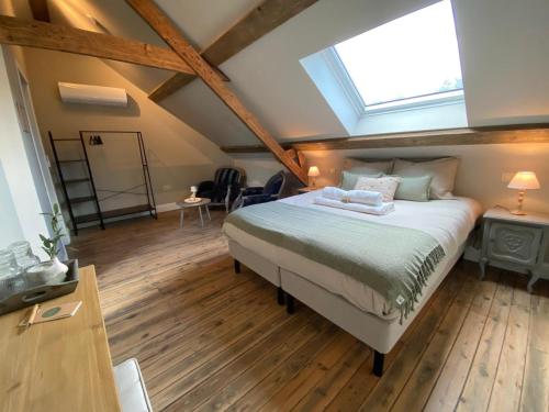 a bedroom with a large bed in a attic at B&B Tierlantijn in Hamont