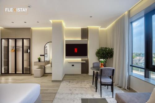 a living room with a tv and a dining room at Flexistay Sheikh Zayed in Sheikh Zayed
