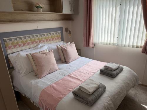 a bedroom with a bed with towels on it at S&K Lodge Billing Aquadrome Holiday Park, Great billing ,Northampton , NN3 9DA in Northampton
